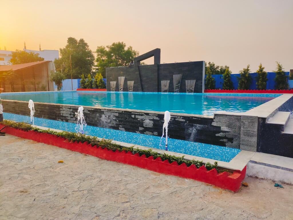 Swimming pool with water features at sunset, built by Dream Pools